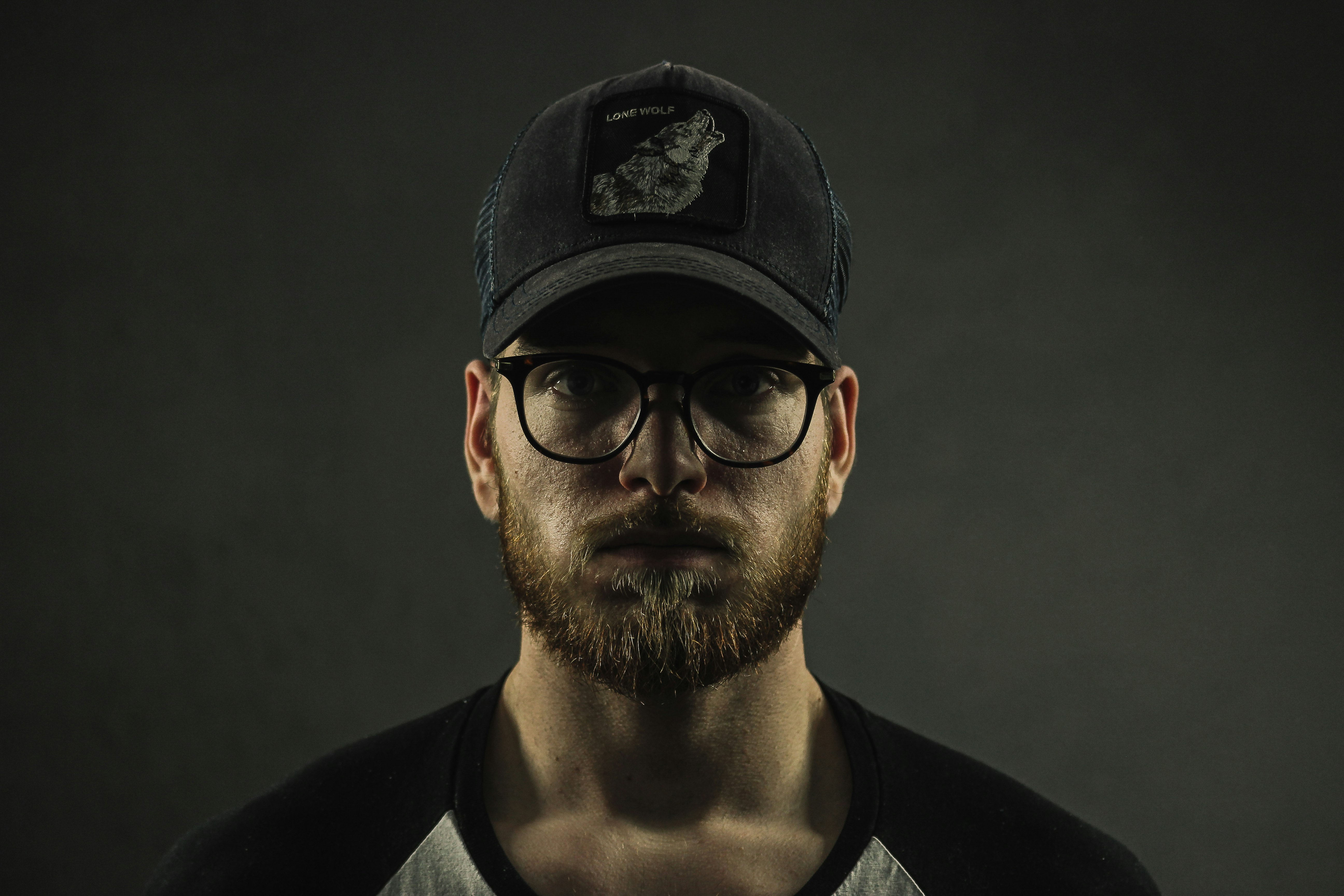 man wearing black curve brim cap and clear eyeglasses with black frames